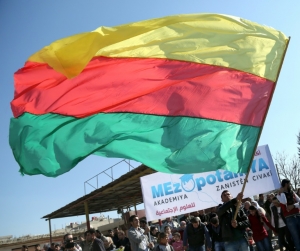 (Fevereiro) Homem agita uma bandeira do principal partido curdo da S&iacute;ria, na cidade de Qamishli