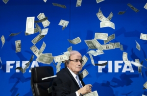 (Arquivo) O presidente da Fifa Sepp Blatter rodeado por notas falsas de d&oacute;lar jogadas por um comediante brit&acirc;nico durante uma coletiva de imprensa em Zurique, na Su&iacute;&ccedil;a, no dia 20 de julho de 2015