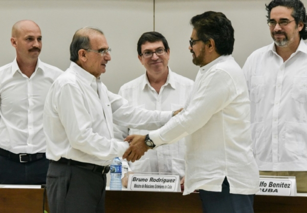 O chefe da delega&ccedil;&atilde;o do govern colombiano, Humberto de la Calle (E), e o chefe da delega&ccedil;&atilde;o das Farc, Ivan M&aacute;rquez, firmam acordo sobre as v&iacute;timas do conflito armado da Col&ocirc;mbia, em Havana, no dia 15 de dezembro de 2015