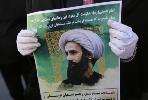 Um iraniano exibe cartaz com foto do cl&eacute;rigo xiita Nimr al-Nimr durante protesto em 3 de janeiro diante da embaixada saudita em Teer&atilde;