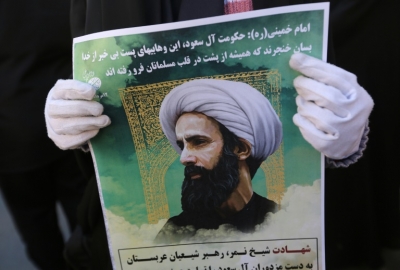 Um iraniano exibe cartaz com foto do cl&eacute;rigo xiita Nimr al-Nimr durante protesto em 3 de janeiro diante da embaixada saudita em Teer&atilde;