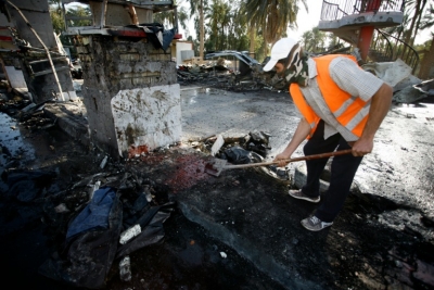 Funcion&aacute;rio dos servi&ccedil;os de emerg&ecirc;ncia recolhe destro&ccedil;os no local de um atentado em Hilla, ao sul de Bagd&aacute;, em 6 de mar&ccedil;o de 2016 The Islamic State jihadist group claimed responsibility for a suicide truck bomb blast that killed at least 47 people in the city of Hilla. / AFP / HAIDAR HAMDANI