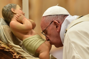 O papa Francisco beija um boneco do menino Jesus, durante a Missa do Galo, na v&eacute;spera de Natal, na bas&iacute;lica de S&atilde;o Pedro, no Vaticano
