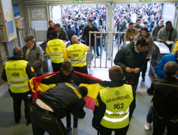 Security frisk supporters before the Spanish league "Clasico" football match Real Madrid CF vs FC Barcelona at the Santiago Bernabeu stadium in Madrid on November 21, 2014. AFP PHOTO / CURTO DE LA TORRE