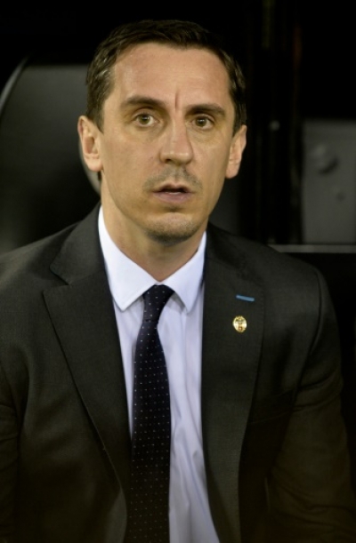 Valencia's Britihs coach Gary Neville sits on the sideline during the UEFA Champions League football match Valencia CF vs Olympique Lyonnais at the Mestalla stadium in Valencia on December 9, 2015.