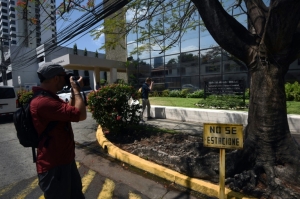 Duas pessoas fotografam o edif&iacute;cio na Cidade do Panam&aacute; que abriga a sede do escrit&oacute;rio de advocacia Mossack Fonseca