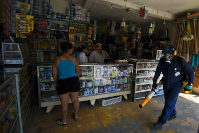 Agentes sanit&aacute;rios fumigam uma loja em Cali, na Col&ocirc;mbia
