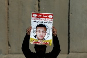 (Arquivo) Palestino mostra um retrato de Mohammed al-Qiq, na Cisjord&acirc;nia