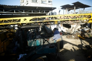 Palestino observa em Gaza os danos a um ve&iacute;culo, em uma &aacute;rea bombardeada por Israel