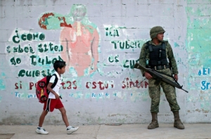 (Arquivo) Um estudante passa por um soldado pr&oacute;ximo a uma escola durante uma opera&ccedil;&atilde;o de seguran&ccedil;a devido &agrave; greve dos professores em Acapulco, no M&eacute;xico, em 17 de novembro de 2015 A boy walks past a Mexican soldier as he stands guard outside a school during a security operation following a teacher's strike in Acapulco, Mexico on November 17, 2015
