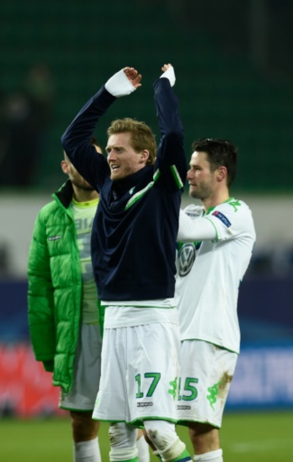 Wolfsburg's striker Andre Schuerrle (c) and teammates react after 1-0 victory during the second-leg round of 16 UEFA Champions league football match between VfL Wolfsburg and KAA Gent at the Volkswagen arena in Wolfsburg on March 8, 2016.
