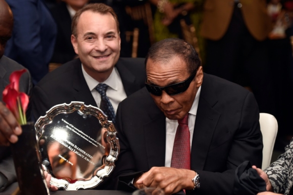 Foto de arquivo de setembro de 2015 mostra Muhammad Ali (D) recebendo um pr&ecirc;mio das m&atilde;os do ent&atilde;o editor do grupo Sports Illustrated, Paul Fichtenbaum, em Louisville, Kentucky