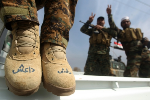 (Arquivo) Um membro das Unidades de Mobiliza&ccedil;&atilde;o Popular mostra suas botas com a sigla 'Daesh' (acr&ocirc;nimo &aacute;rabe para o grupo Estado Isl&acirc;mico) durante uma opera&ccedil;&atilde;o na cidade de Tikrit, no Iraque, em 9 de mar&ccedil;o de 2015