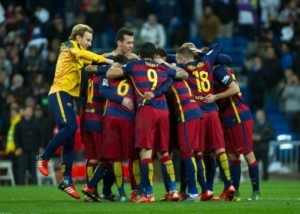 Barcelona's players celebrate at the end of the Spanish league "Clasico" football match Real Madrid CF vs FC Barcelona at the Santiago Bernabeu stadium in Madrid on November 21, 2014. AFP PHOTO / CURTO DE LA TORRE