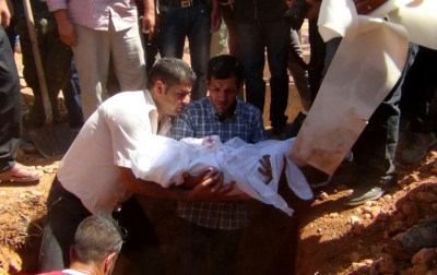 O pai de Aylan Kurdi, que teve a foto de seu corpo transformada em s&iacute;mbolo da crise dos refugiados, segura o corpo do filho durante o funeral em Kobane, S&iacute;ria, em 4 de setembro