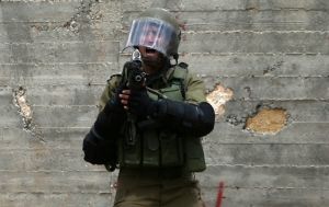 Membro das for&ccedil;as de seguran&ccedil;a israelenses grita durante confrontos com manifestantes palestinos em Kfar Qaddum em 6 de maio de 2016