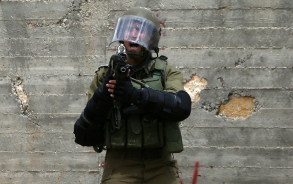 Membro das for&ccedil;as de seguran&ccedil;a israelenses grita durante confrontos com manifestantes palestinos em Kfar Qaddum em 6 de maio de 2016